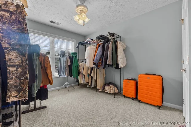 a view of walk in closet with clothes