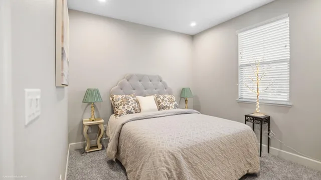 a bed sitting in a bedroom next to a window