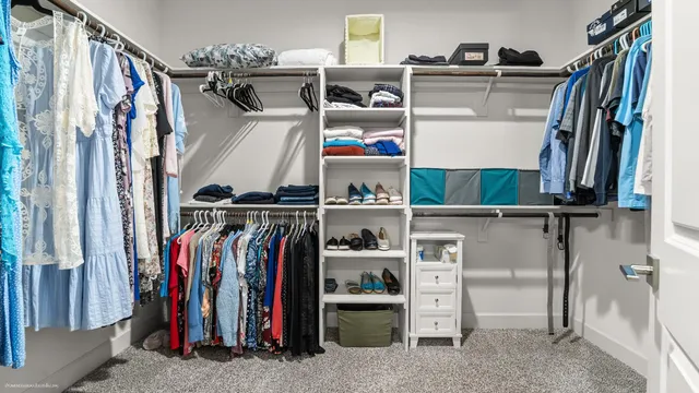 a view of walk in closet with clothes and shoes