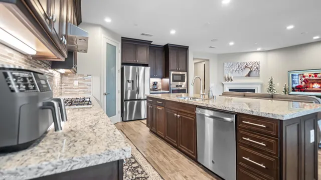 a kitchen with stainless steel appliances granite countertop a sink stove and refrigerator