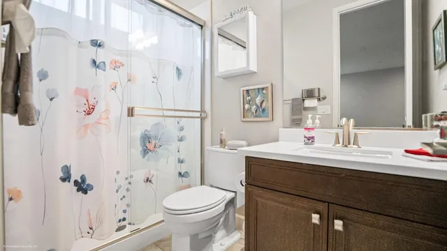 a bathroom with a sink vanity mirror and toilet