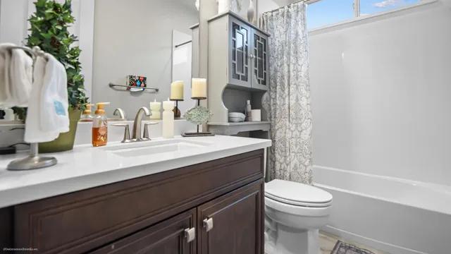 a bathroom with a sink a toilet a mirror and shower