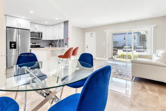 a living room with stainless steel appliances furniture a dining table and chairs