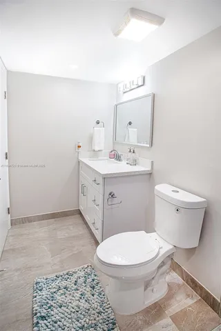 a white toilet sitting next to a bathroom sink