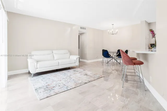a living room with furniture a rug and a chandelier
