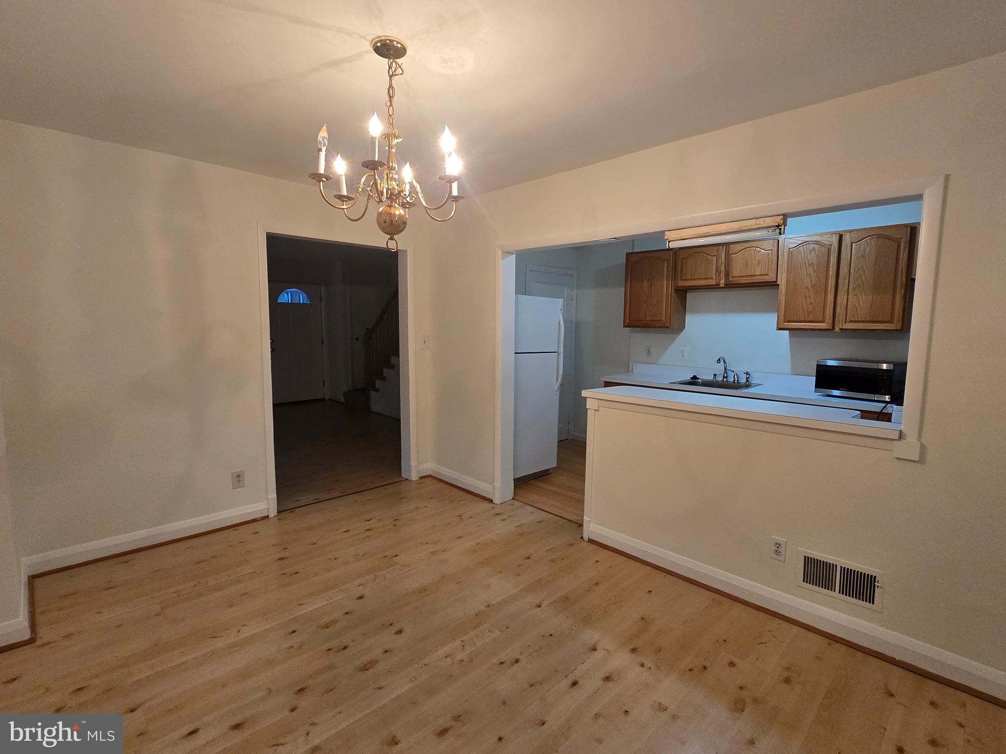 8625 Black Oak Road Baltimore, MD 21234 - Photo 23 of 36 a view of a hallway with wooden floor and chandelier