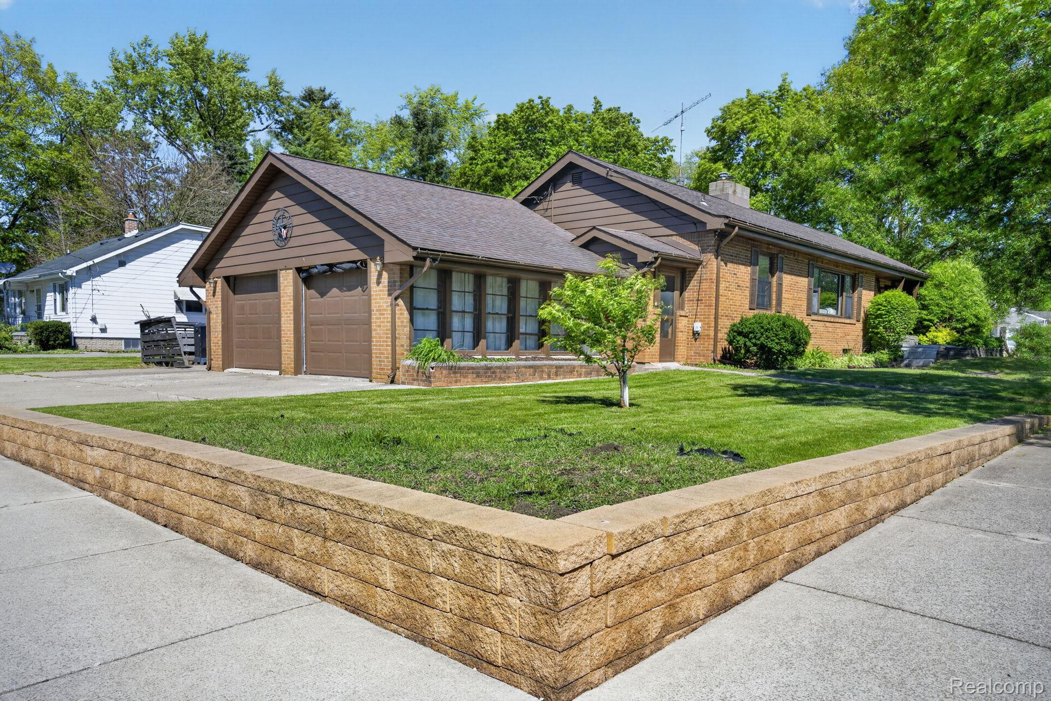 1209 Beatrice Street Flushing, MI 48433 - Photo 1 of 39 Ranch-style home with a front yard, brick siding, concrete driveway, an attached garage, and a chimney
