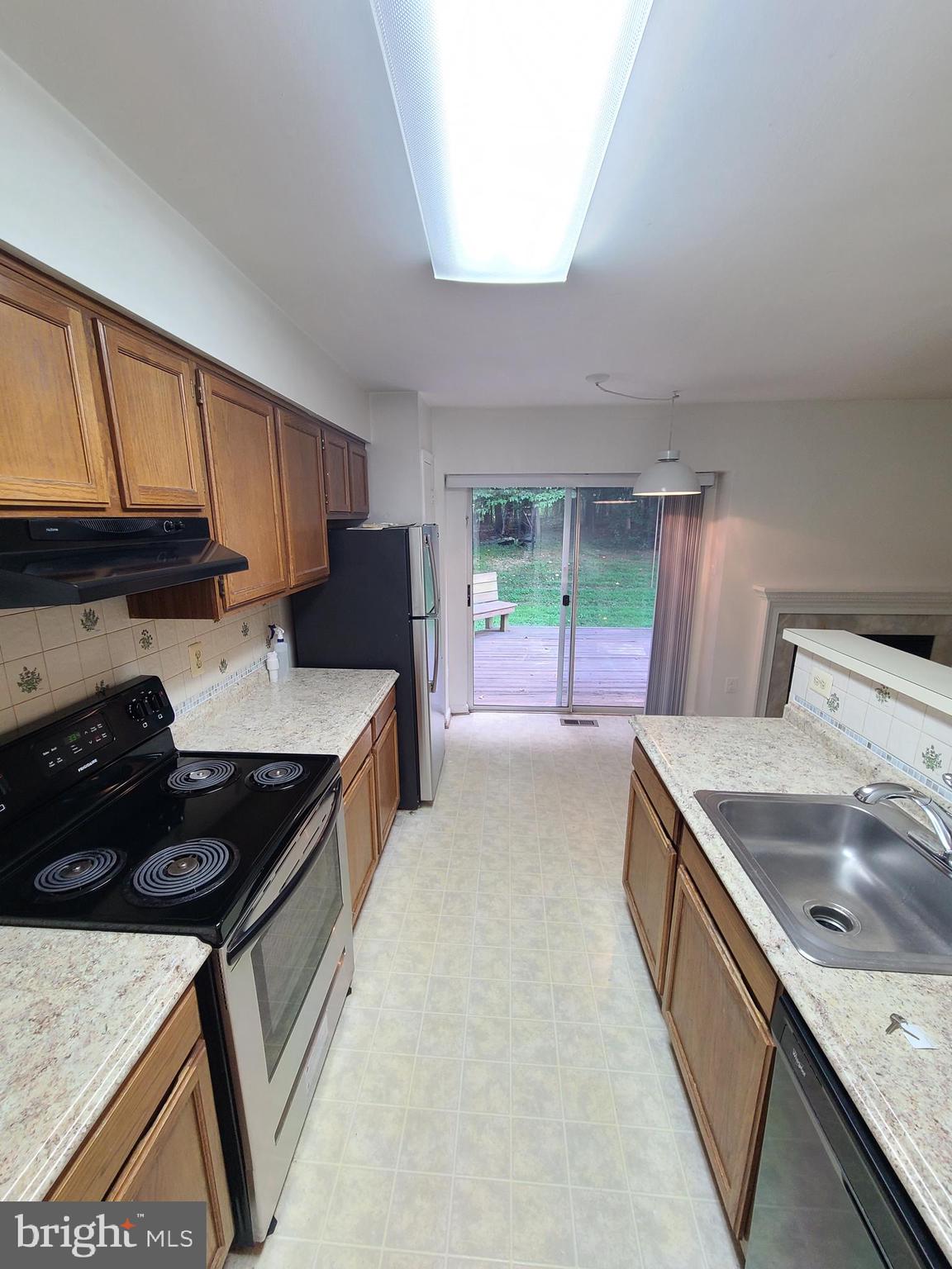 1427 Casino Circle Silver Spring, MD 20906 - Photo 8 of 34 a kitchen with granite countertop a sink a stove and a wooden cabinets