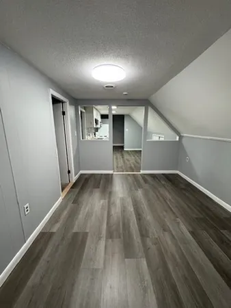 an empty room with wooden floor and entrance