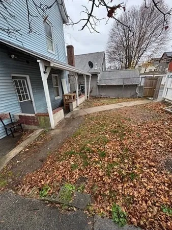 a view of a brick house with wooden fence