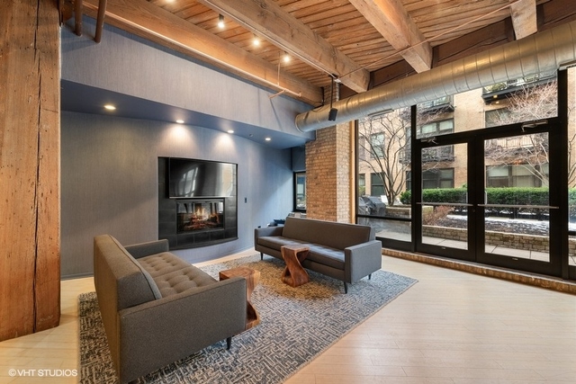 1040 West Adams Street, Unit 610 Chicago, IL 60607 - Photo 2 of 24 a living room with furniture a flat screen tv and floor to ceiling window