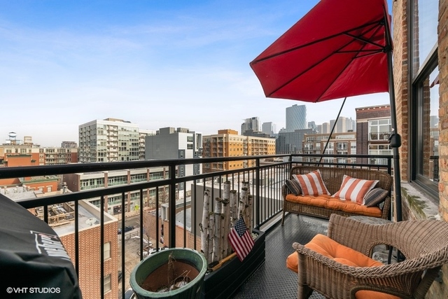 1040 West Adams Street, Unit 610 Chicago, IL 60607 - Photo 17 of 24 a view of a balcony with table and chairs under an umbrella