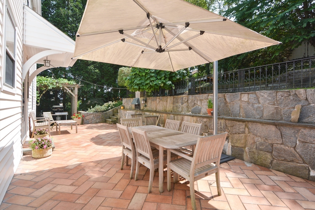 10 Radcliffe Road Belmont, MA 02478 - Photo 2 of 19 a view of a patio with a table and chairs under an umbrella