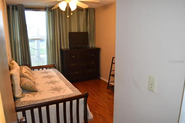 a bedroom with a bed and a flat tv screen on dresser