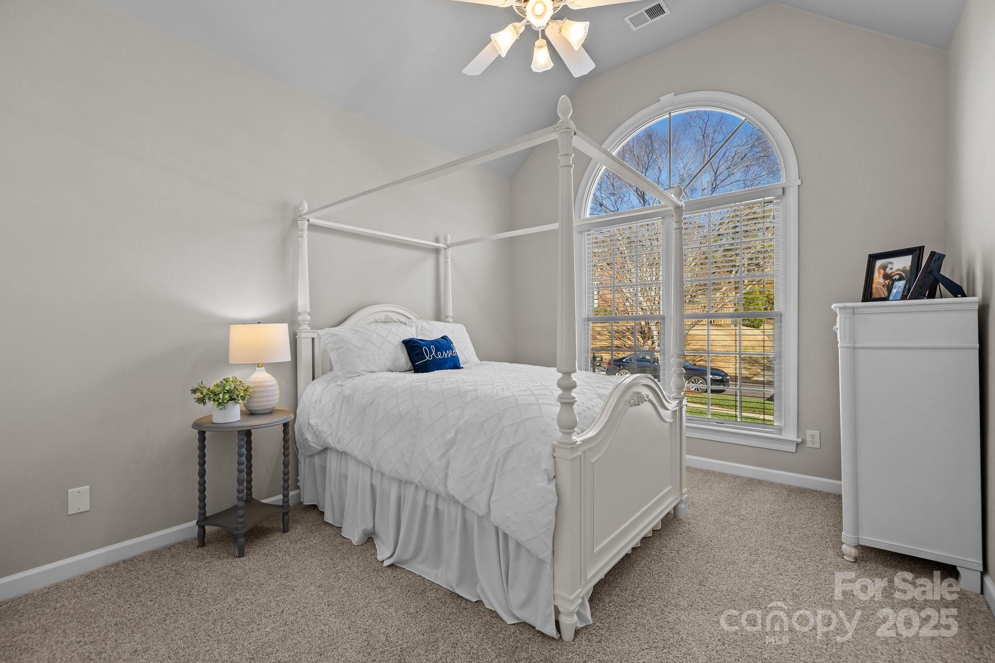 3065 River Bend Drive Tega Cay, SC 29708 - Photo 13 of 29 a bedroom with a bed and a chandelier