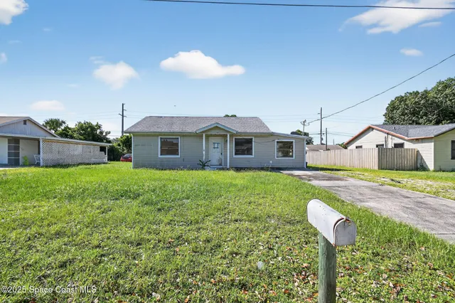 a front view of house with yard and trees
