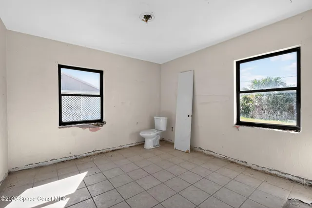 a spacious bedroom with a bed and a window