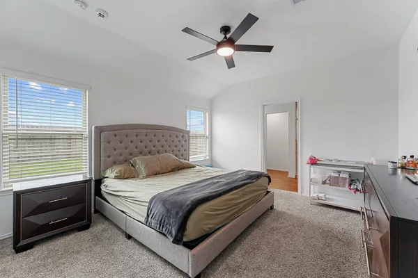 a bedroom with a bed and a ceiling fan