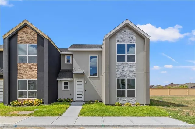 a front view of a house with a garden and yard