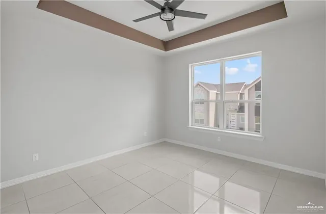 an empty room with windows and fan