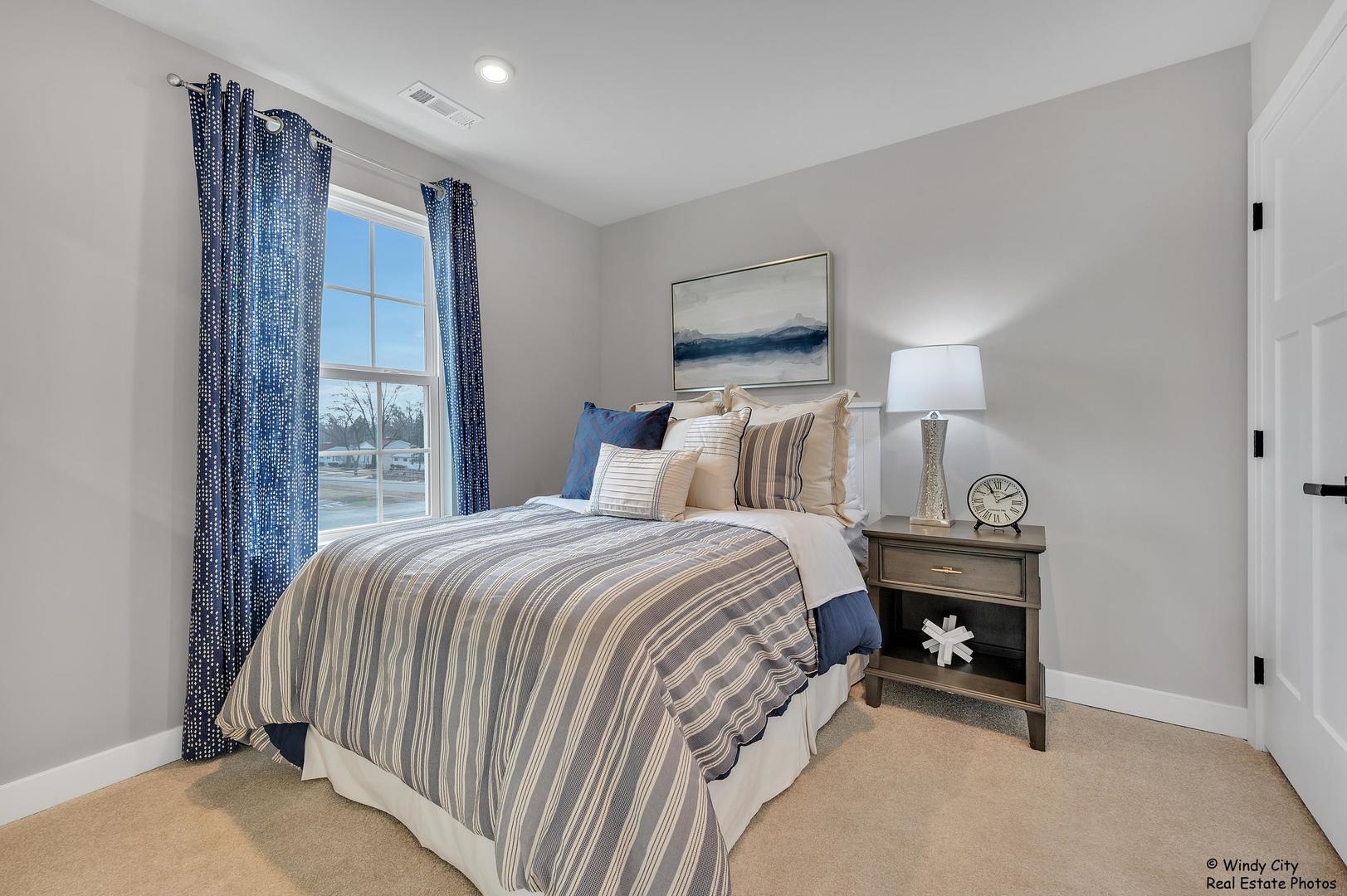 908 Jenkins Court Wheeling, IL 60090 - Photo 18 of 20 a bedroom with a bed a lamp and a large window