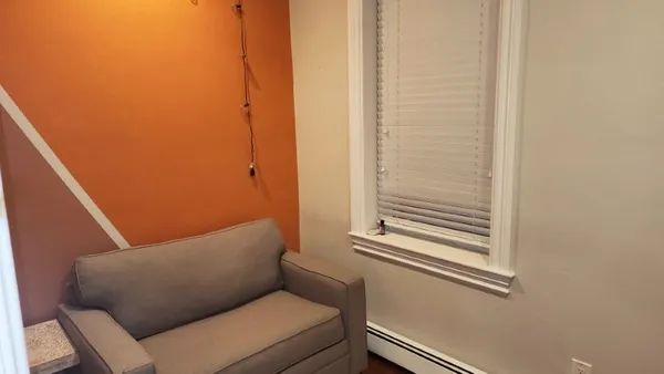 a blue couch sitting next to a small bathroom