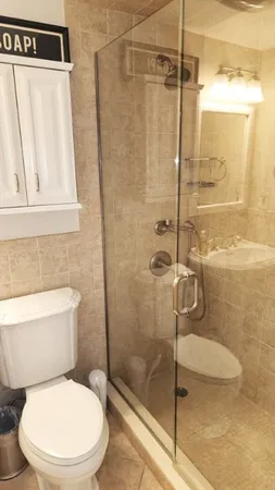 a bathroom with a sink mirror and toilet