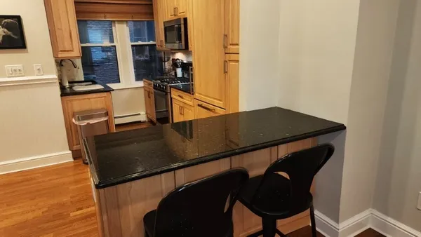 a kitchen with granite countertop a refrigerator stove and microwave