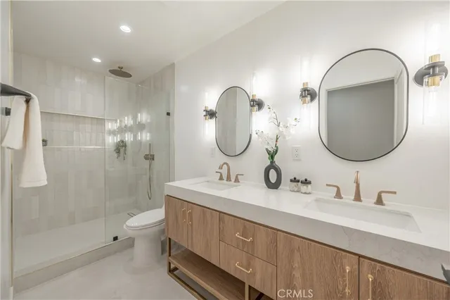 a bathroom with a double vanity sink mirror and shower