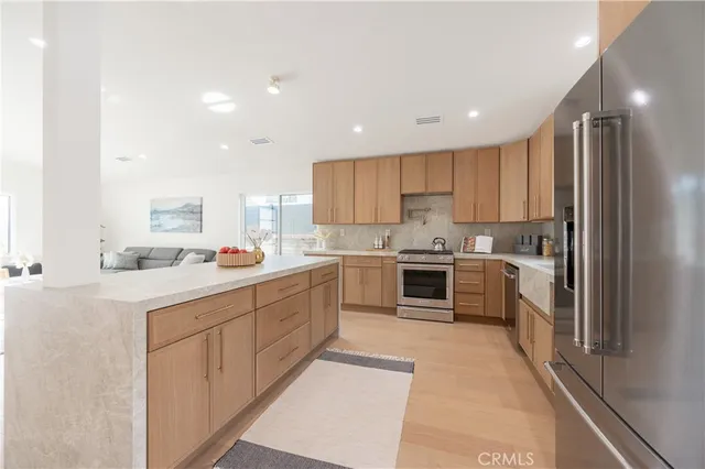 a kitchen with a sink a counter top space stainless steel appliances and cabinets