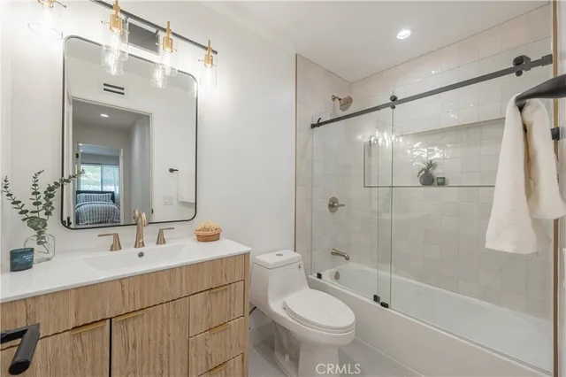 a bathroom with a sink double vanity mirror and a shower