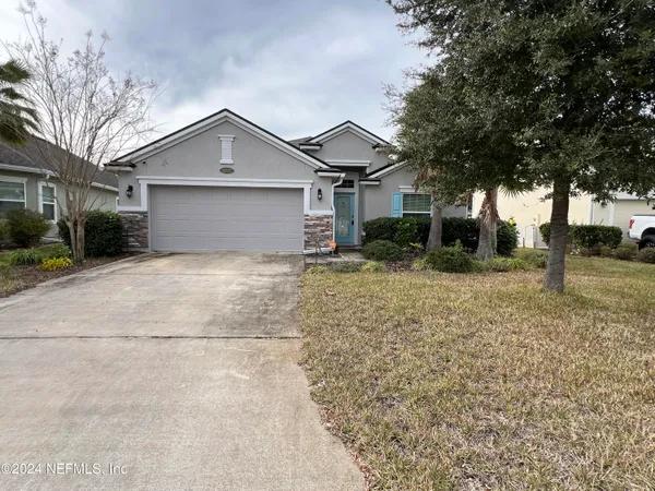 a front view of house with yard and trees