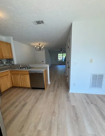 a view of a kitchen counter space wooden floor electric appliances and windows