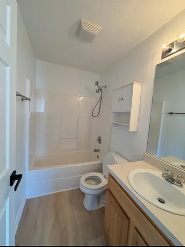 a bathroom with a sink a toilet and a large mirror