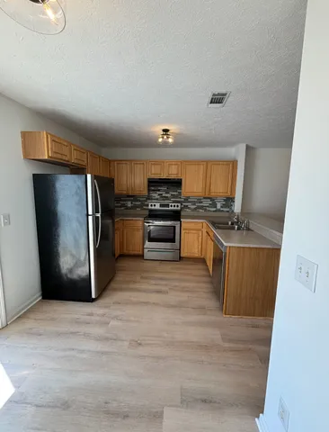 a kitchen with stainless steel appliances granite countertop a refrigerator stove and oven