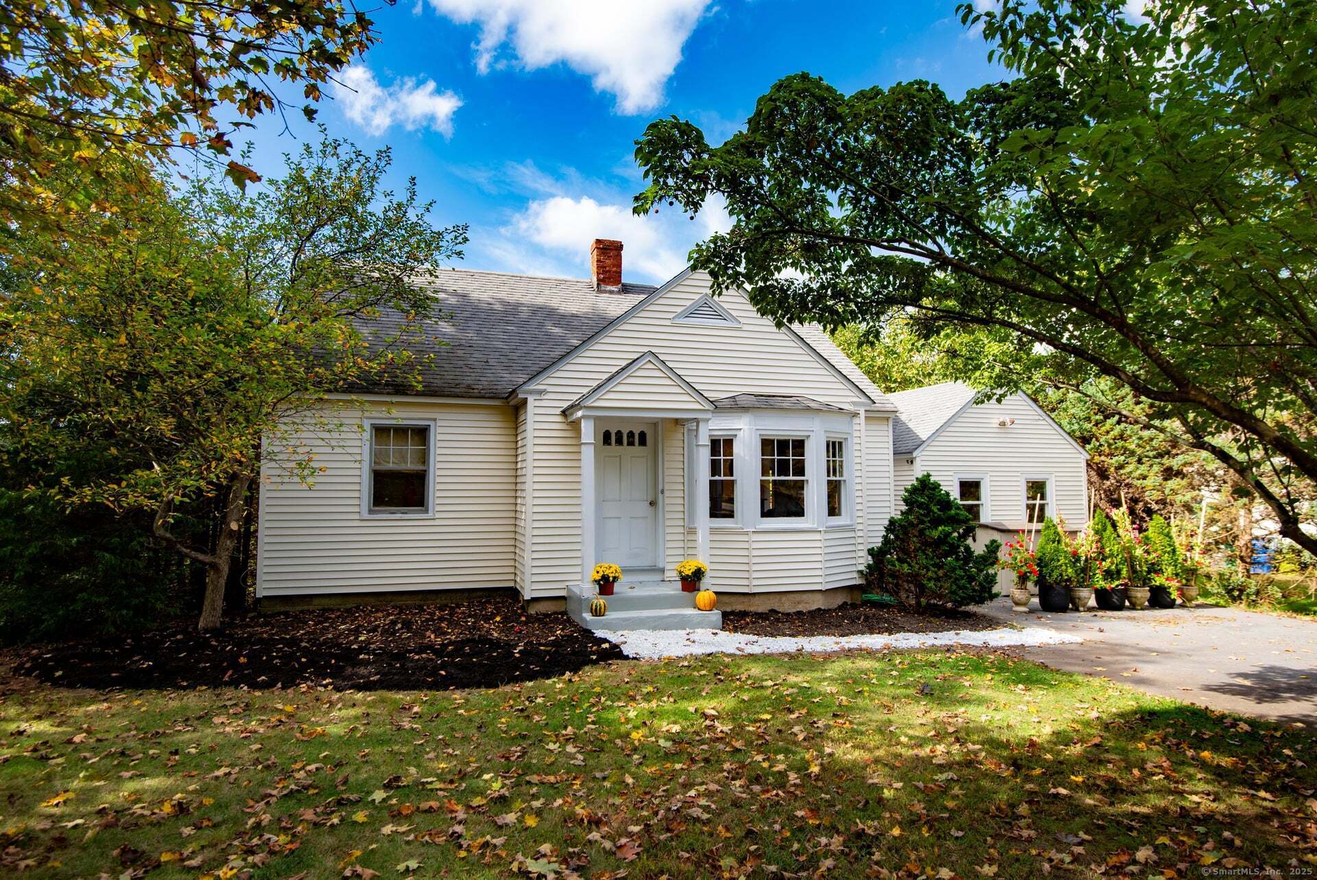 a front view of house with yard and trees in the background