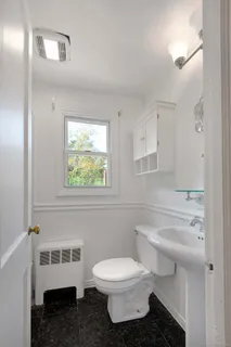 a bathroom with a toilet sink and mirror