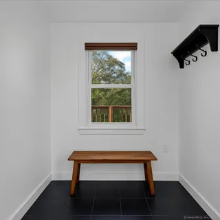 a bench sitting in a bedroom next to a window