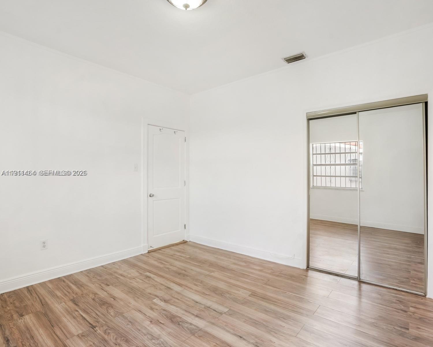 5629 Southwest 7th Street Miami, FL 33144 - Photo 12 of 25 an empty room with wooden floor and windows