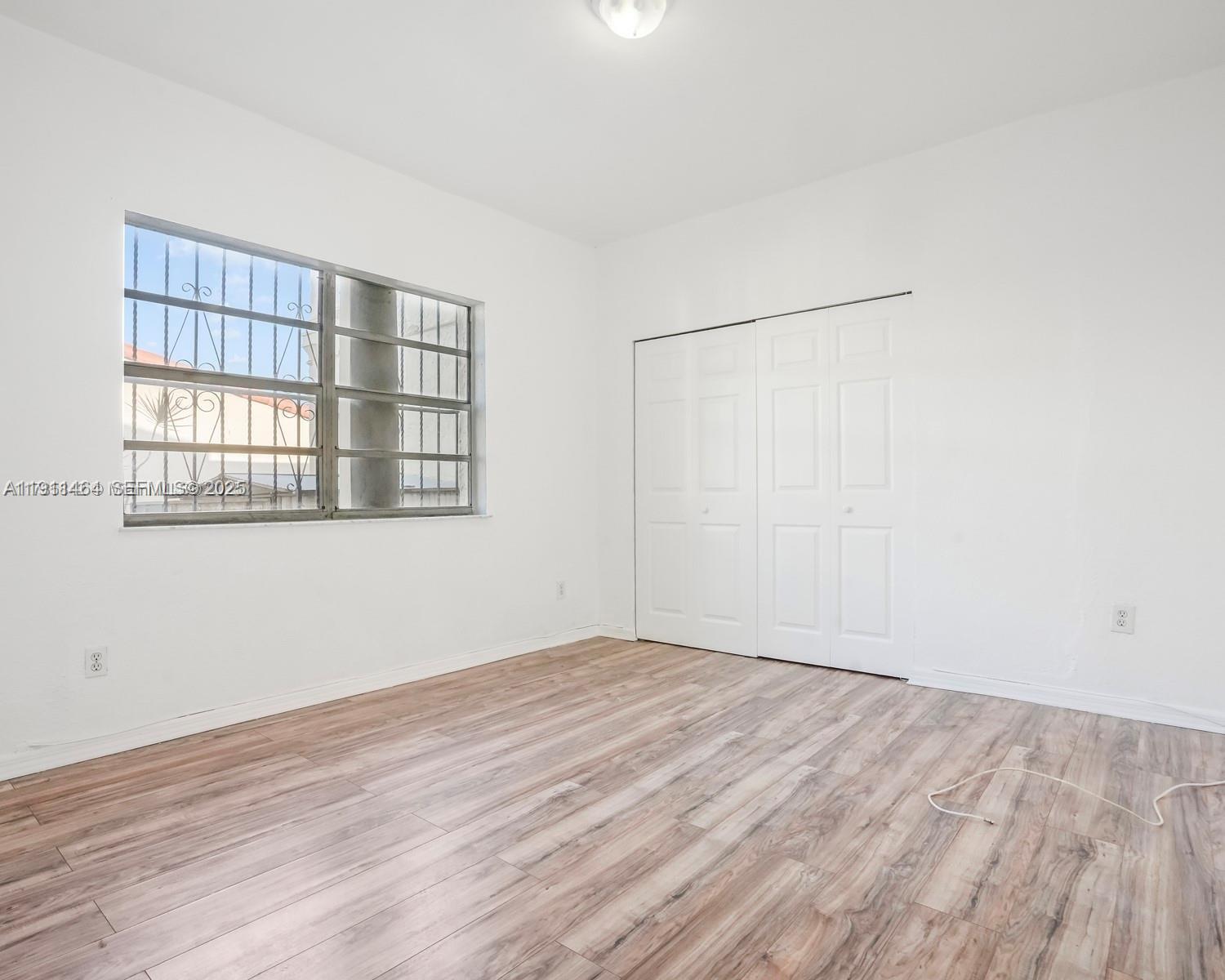 5629 Southwest 7th Street Miami, FL 33144 - Photo 13 of 22 wooden floor in an empty room with a window