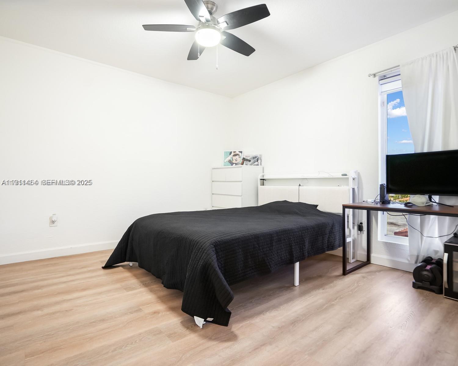 5629 Southwest 7th Street Miami, FL 33144 - Photo 19 of 22 a bedroom with a bed and a flat tv screen on a dresser