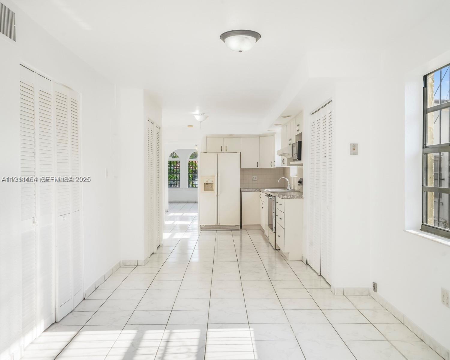 5629 Southwest 7th Street Miami, FL 33144 - Photo 8 of 22 a view of a kitchen with wooden floor and a refrigerator