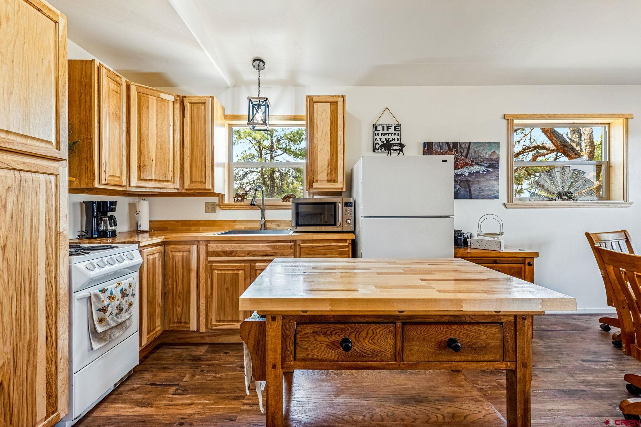 1788 Foxfire Road Bayfield, CO 81122 - Photo 4 of 34 a kitchen with stainless steel appliances granite countertop a table chairs and a refrigerator