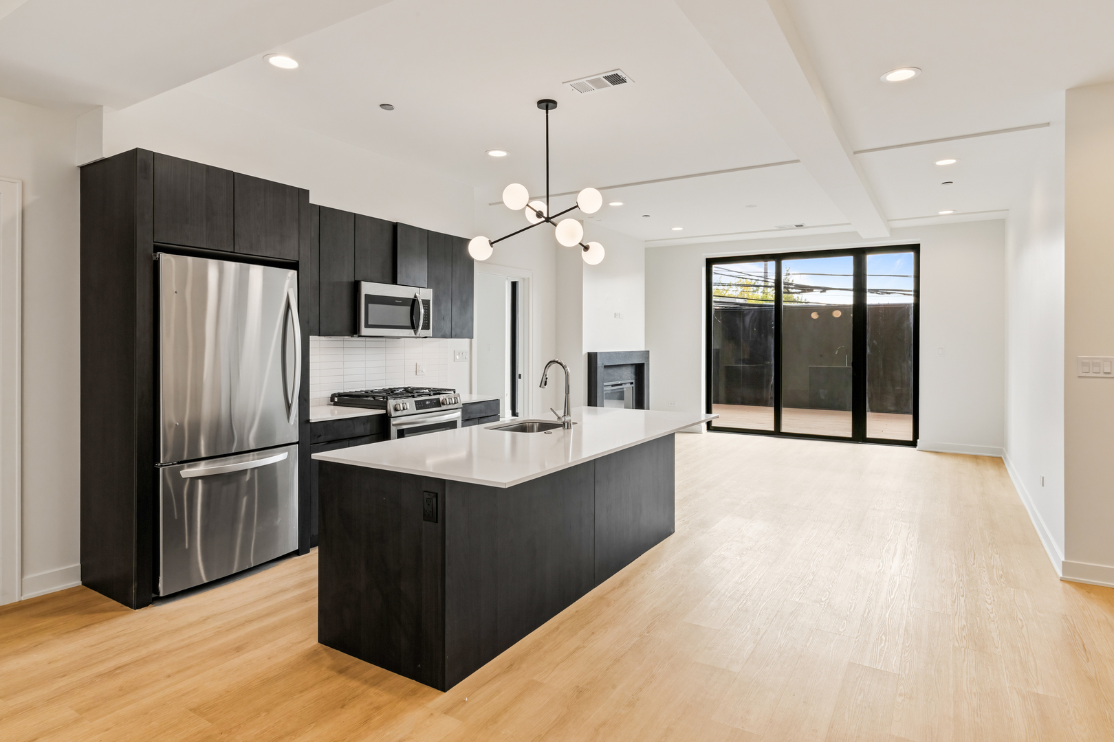 1801 West Grand Avenue, Unit 202 Chicago, IL 60622 - Photo 3 of 18 a large kitchen with kitchen island a sink stainless steel appliances and cabinets