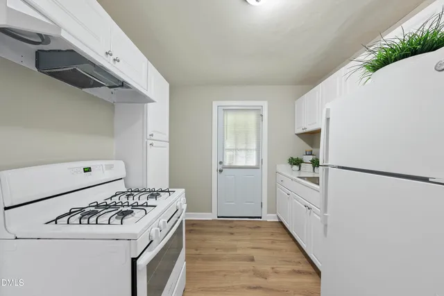a kitchen with white cabinets and white appliances