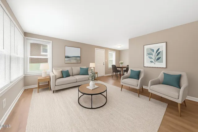 a living room with furniture a rug and a window