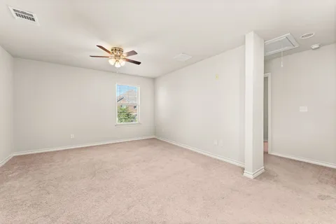 an empty room with windows and ceiling fan