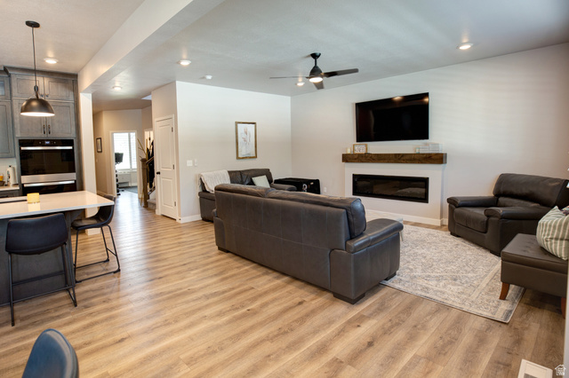 983 South 950 West Provo, UT 84601 - Photo 9 of 56 Open-concept living space featuring wood-finish flooring, a contemporary fireplace with a wood mantle, and recessed lighting