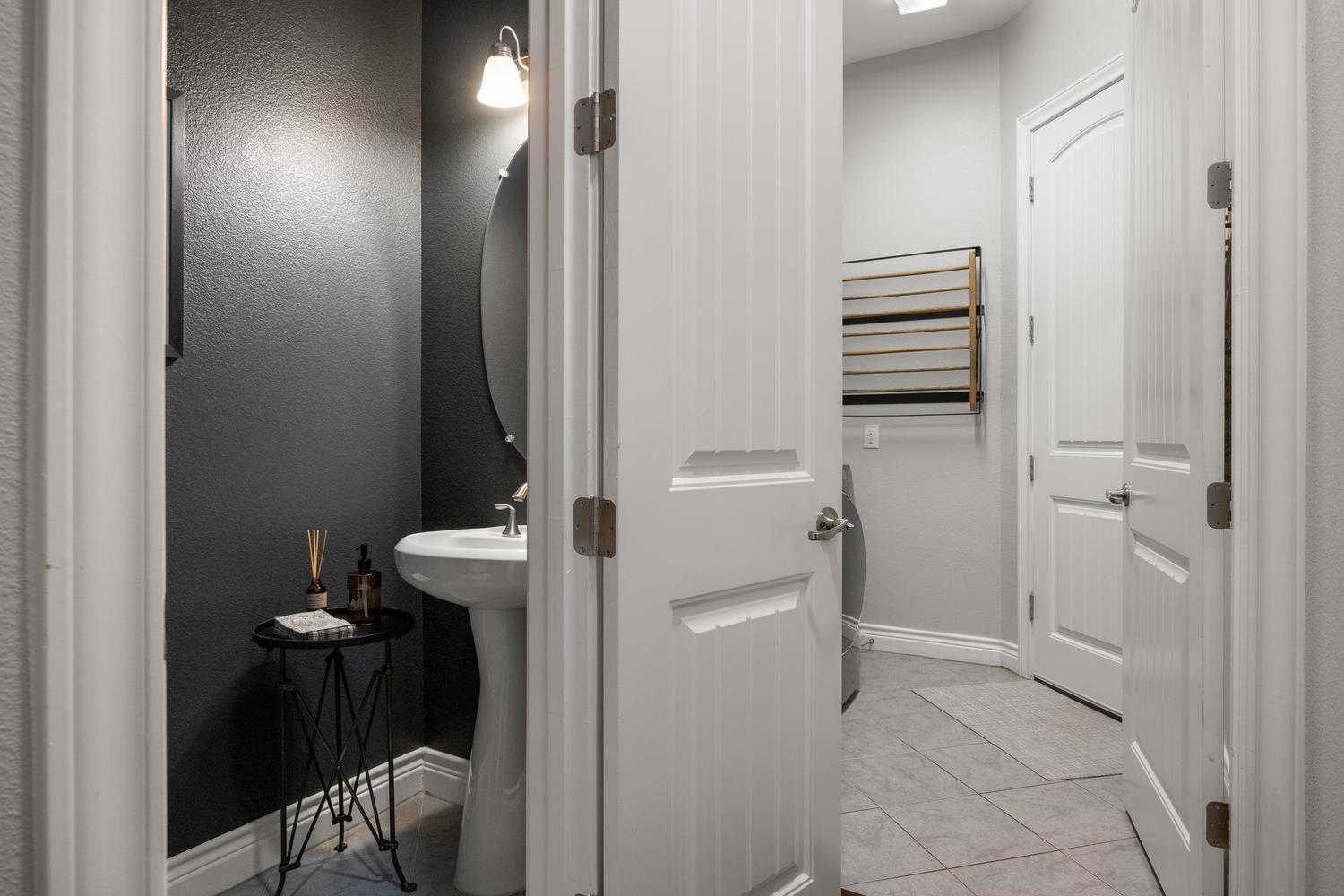 1135 Blue Ridge Drive Dripping Springs, TX 78620 - Photo 24 of 36 A compact laundry and powder room with a sleek pedestal sink and practical tile flooring.