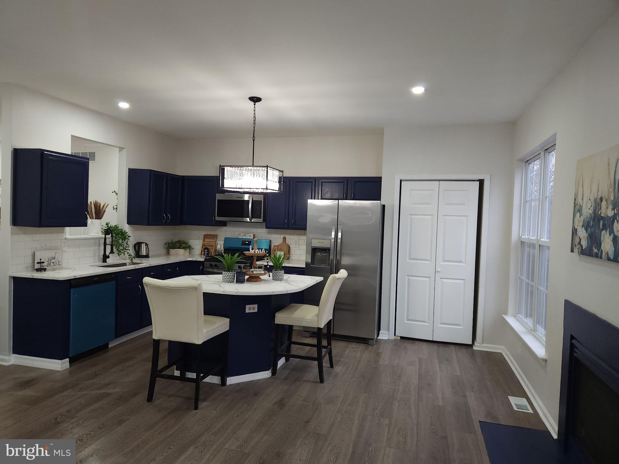 247 Becks Woods Drive Bear, DE 19701 - Photo 10 of 58 a kitchen with a dining table chairs refrigerator and cabinets